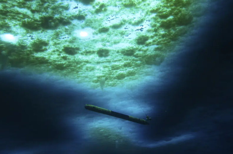 A skinny robot is seen under ice in the water.