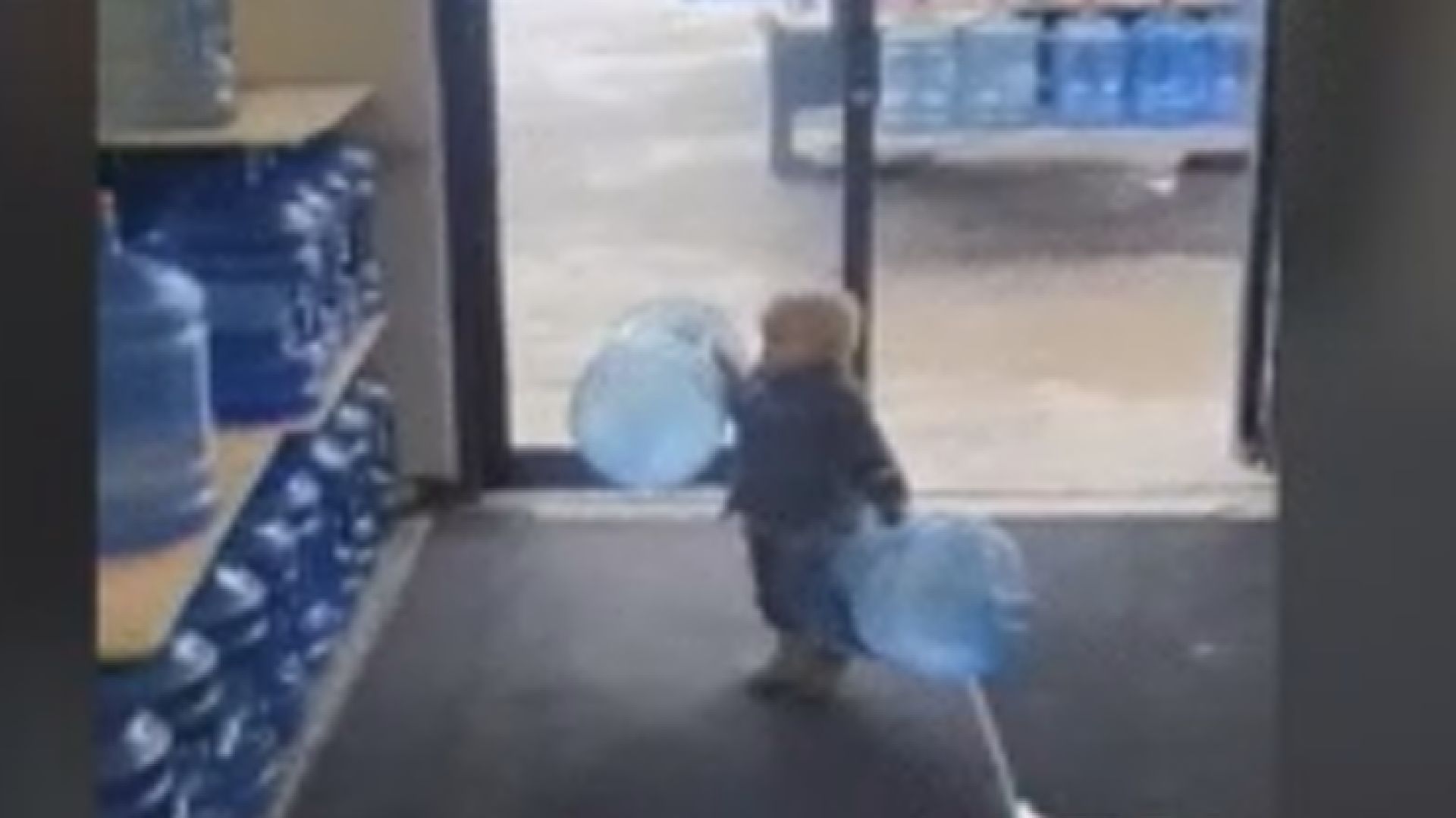 Young boy (6-8) holding an armful of recyclable plastic bottles