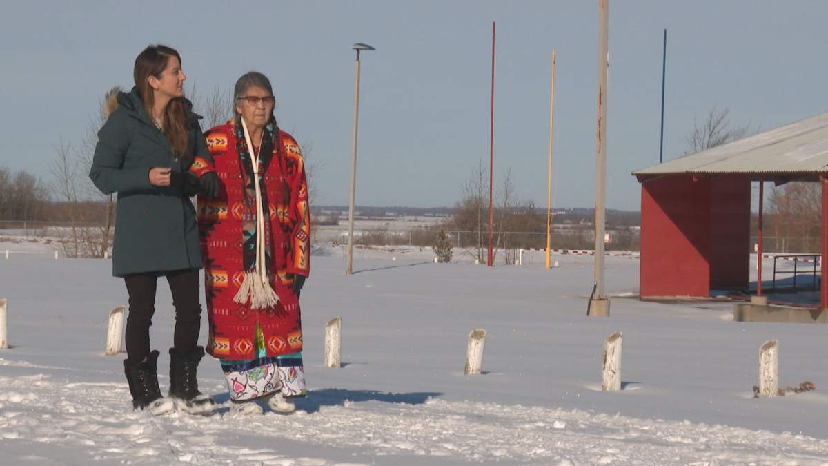 Daintre Christensen walks with Elder Mary at the Ermineskin Cree Nation Powwow grounds,.