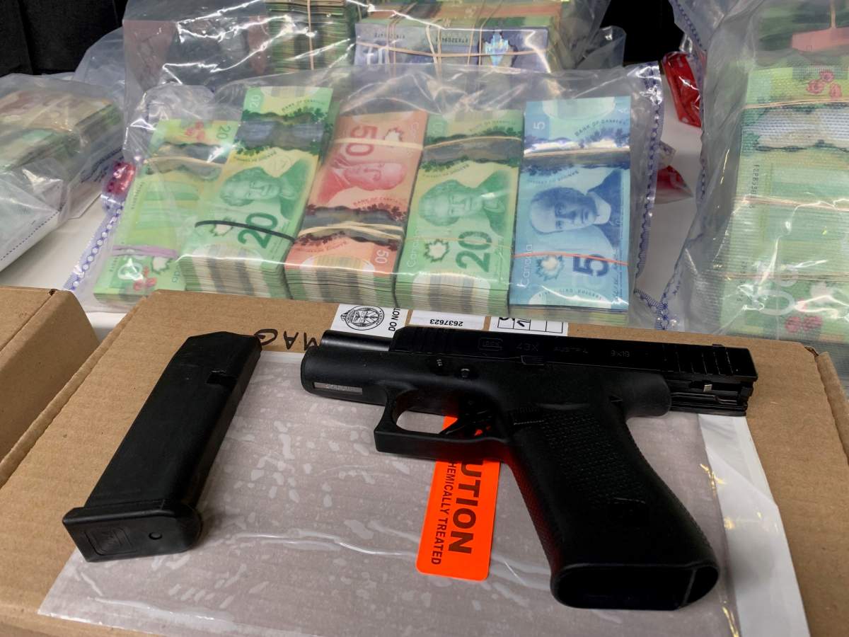 Cash and guns seized from Project Cerro on display at Toronto Police Headquarters on Feb. 1, 2023.