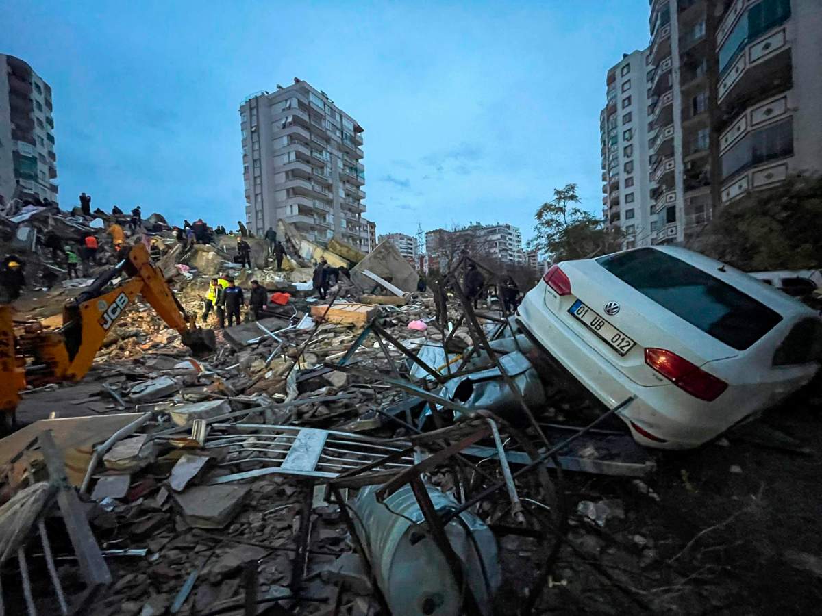 Emergency teams search for people in a destroyed building in Adana, Turkey, Monday, Feb. 6, 2023.