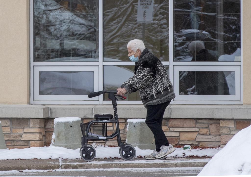 A woman walks outside a long-term care home in Barrie, Ont. on Monday, January 18, 2021.