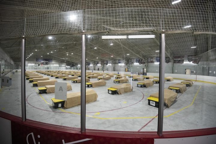Beds and bins for personal belongings sit on an ice rink that has been converted into a temporary shelter for single men at Jim Durrell Arena in Ottawa, during the COVID-19 pandemic on Wednesday, April 29, 2020. Ottawa is turning to its pandemic-era temporary shelters to house vulnerable populations while the city searches for a long-term plan to find permanent homes. .