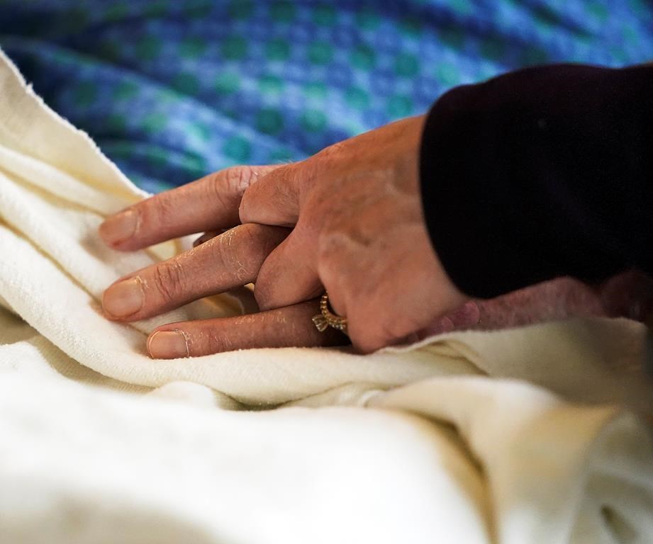 A patient has his hand held at a hospital, in Minneapolis, Monday, May 3, 2021.