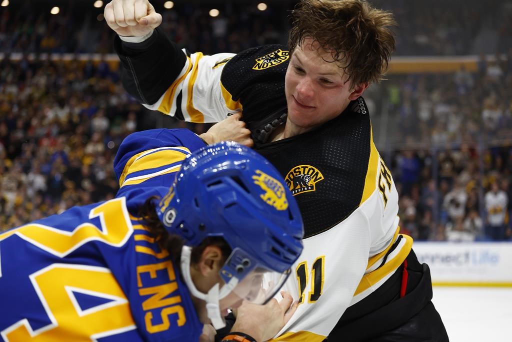 Boston Bruins centre Trent Frederic (11) and Buffalo Sabres centre Dylan Cozens (24) fight during the second period of an NHL hockey game, Sunday, March 19, 2023, in Buffalo, N.Y.