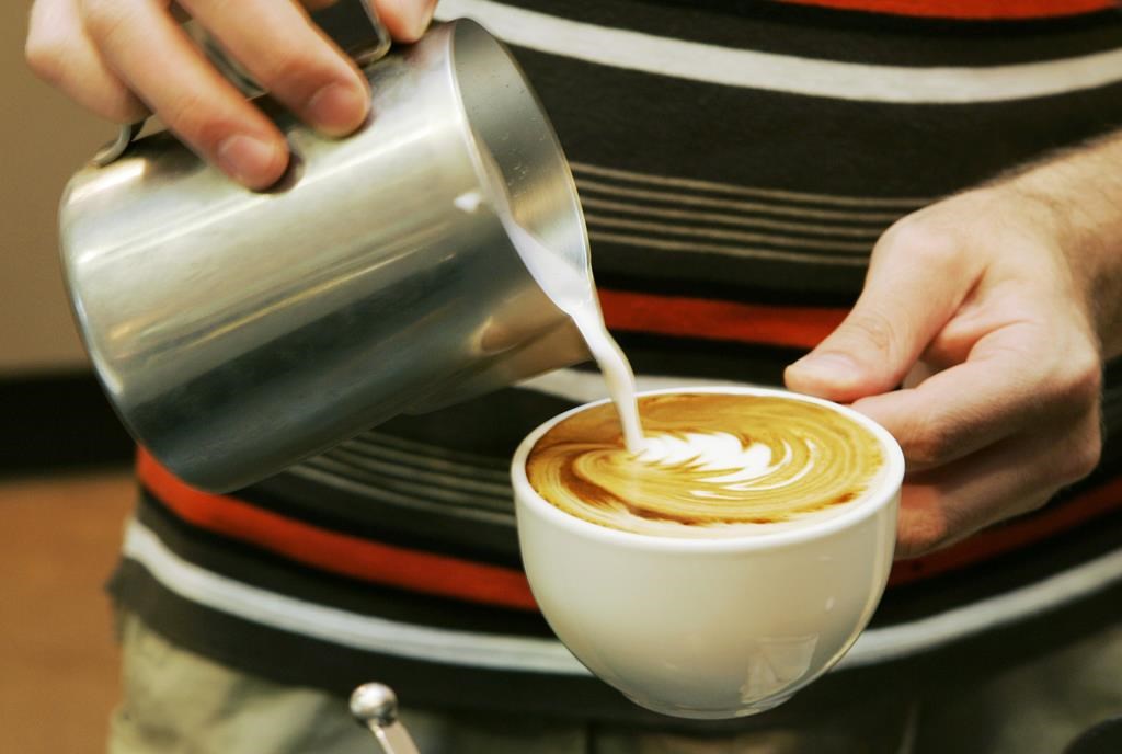 FILE - A worker prepares a coffee drink at a shop in Overland Park, Kan., Thursday, Aug. 14, 2008. In a study published in the New England Journal of Medicine on Wednesday, March 22, 2023, healthy volunteers who were asked to drink coffee or skip it on different days showed no signs of an increase in a certain type of heart rhythm after sipping the caffeinated drinks, although they did walk more and sleep less. (AP Photo/Orlin Wagner).