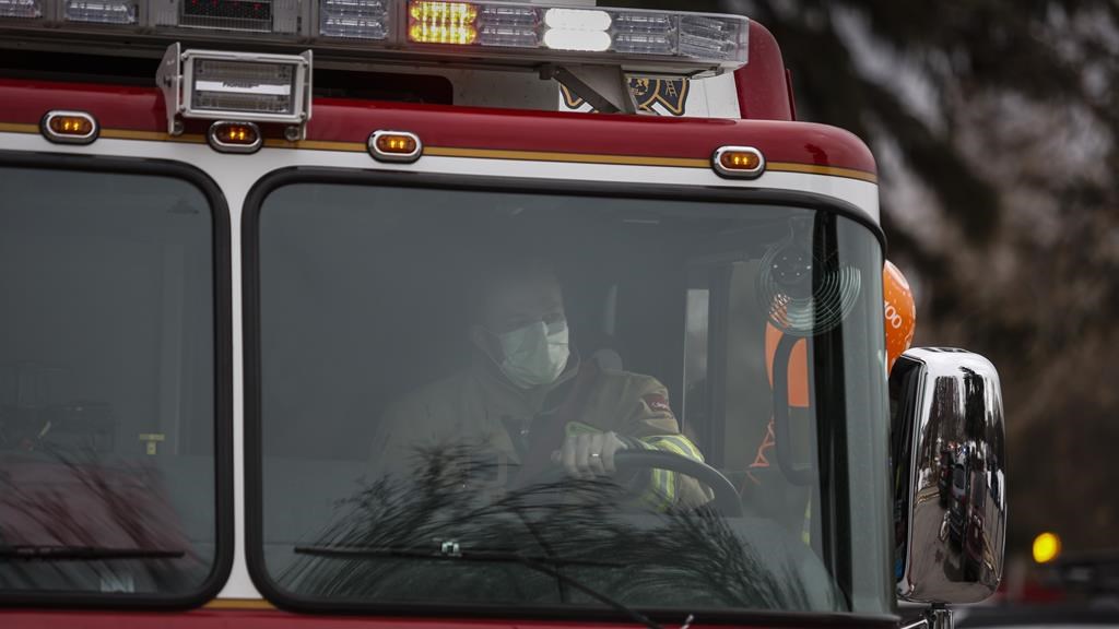 A Calgary Fire Department firefighter drives a fire truck in Calgary.
