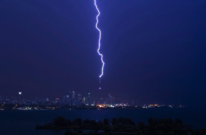 A lightning bolt strikes the CN Tower during an electrical storm in Toronto, Thursday July 14, 2016. 