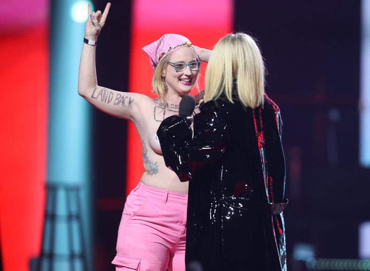 Avril Lavigne confronts topless protester Casey Hatherly, who goes by the first name Ever, as she presents during the Junos Monday, March 13, 2023. 