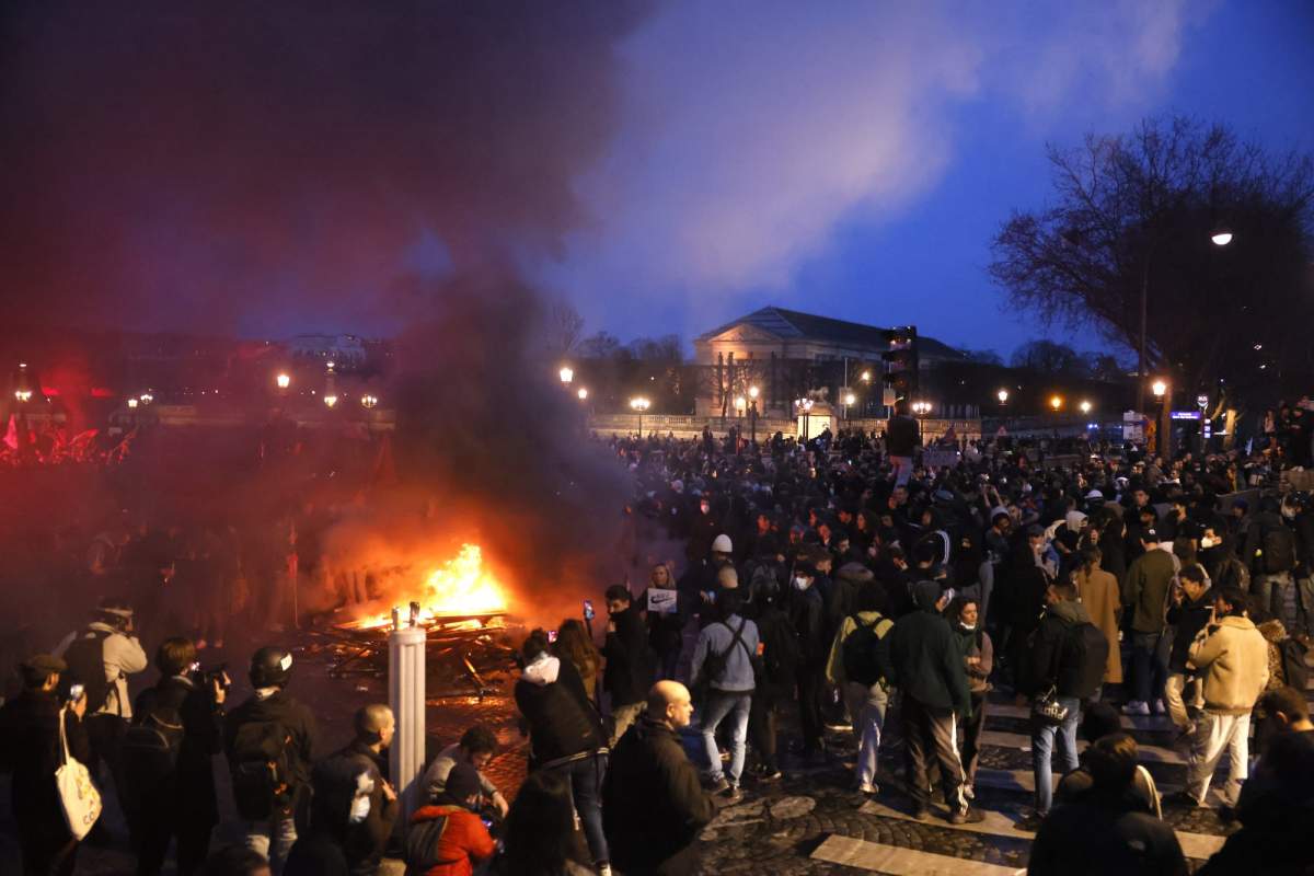 Pallets burn as protesters demonstrate at Concorde square near the National Assembly in Paris, Thursday, March 16, 2023. French President Emmanuel Macron has shunned parliament and opted to push through a highly unpopular bill that would raise the retirement age from 62 to 64 by triggering a special constitutional power. (AP Photo/Thomas Padilla)