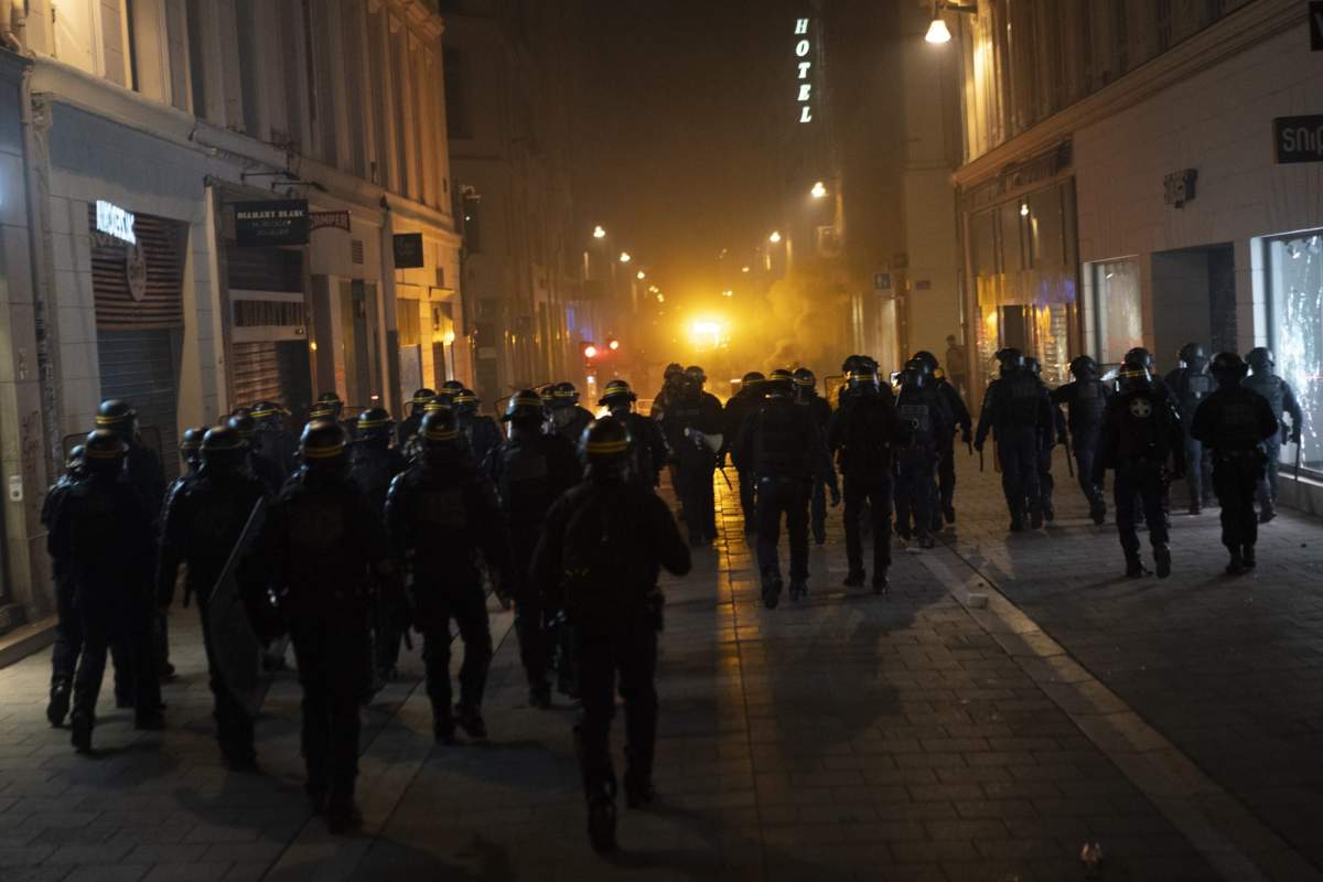Police advance as protesters light bins on fire during a demonstration in Marseille, southern France, Thursday, March 16, 2023.