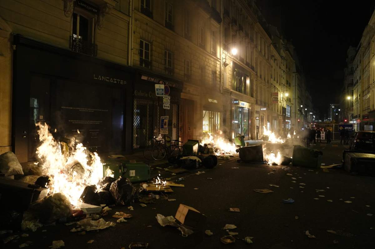 Garbages are set on fire by protesters after a demonstration near Concorde square, in Paris, Thursday, March 16, 2023