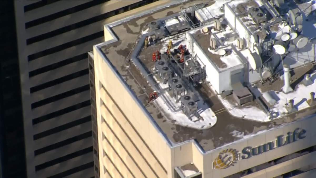 A Calgary Fire Department prepares to descend down the exterior of a downtown high rise on March 2, 2023, to secure a piece of flashing that likely came loose from high winds.