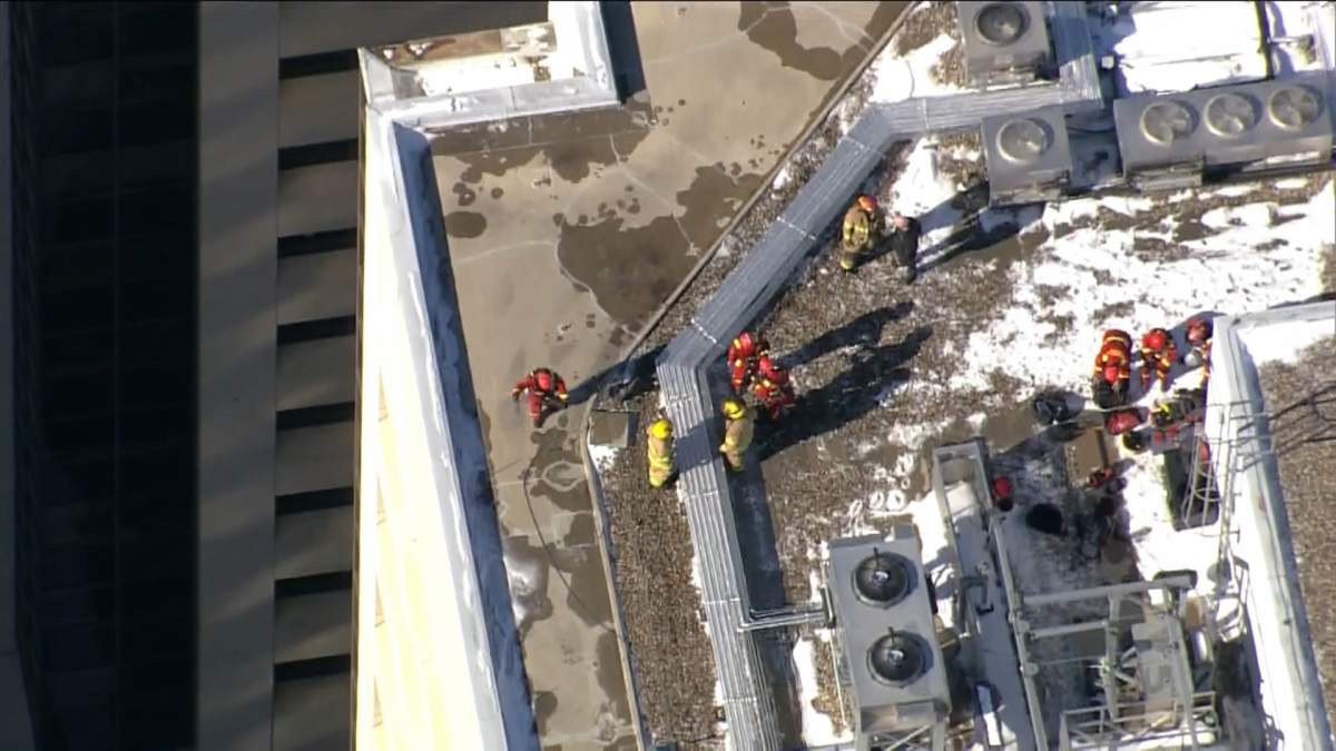 A Calgary Fire Department prepares to descend down the exterior of a downtown high rise on March 2, 2023, to secure a piece of flashing that likely came loose from high winds.