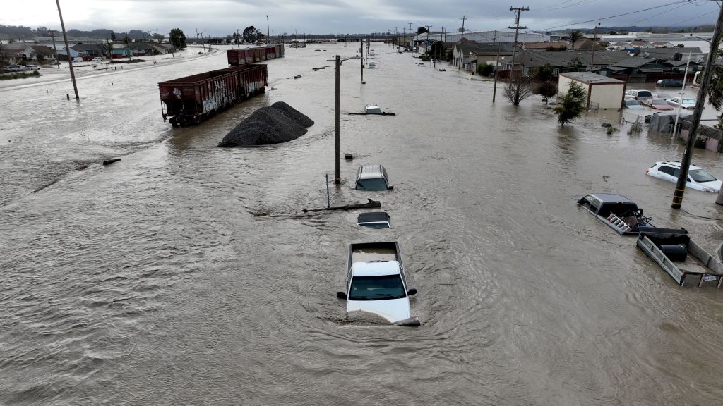 This aerial photograph shows train cars, vehicles and homes in floodwaters in Pajaro, Calif., on Saturday, March 11, 2023.