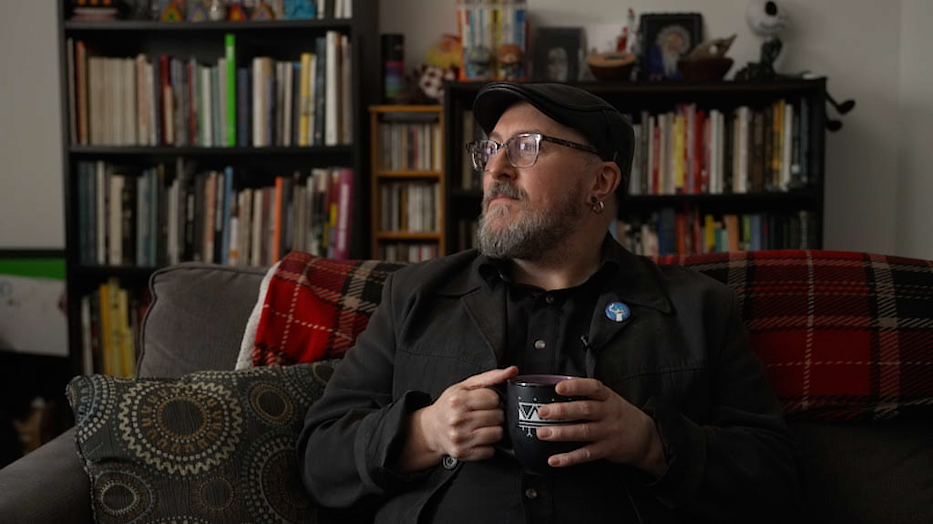 Glenn Gear, a multi-disciplinary artist and filmmaker looks out the window from the couch in the living room of his Montreal apartment.