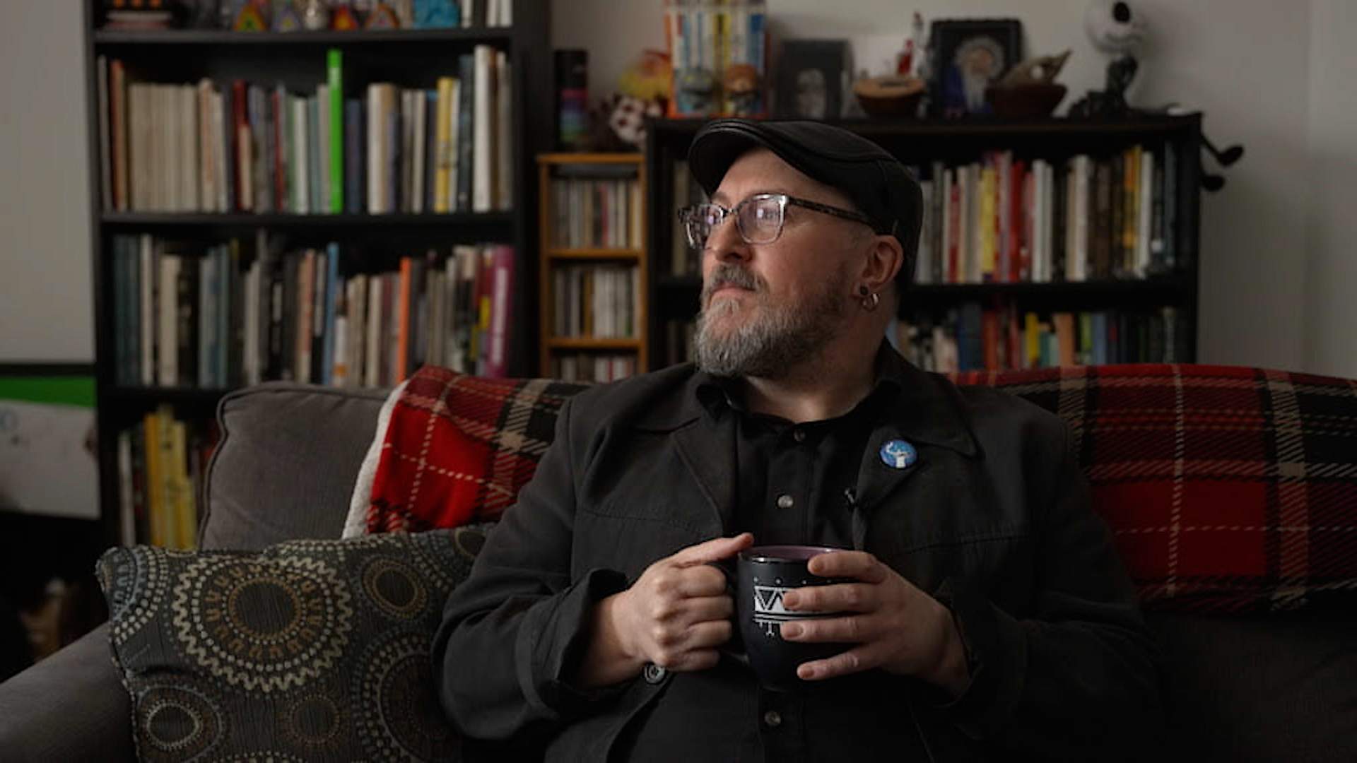 Glenn Gear, a multi-disciplinary artist and filmmaker looks out the window from the couch in the living room of his Montreal apartment.