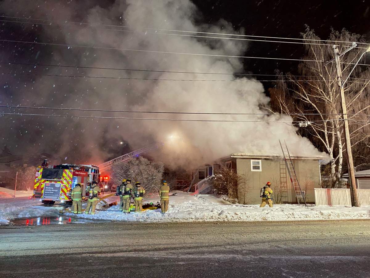 Calgary firefighters work to put out a fire at an unoccupied home at the corner of 4 Street and 35 Avenue NW on March 1, 2023.