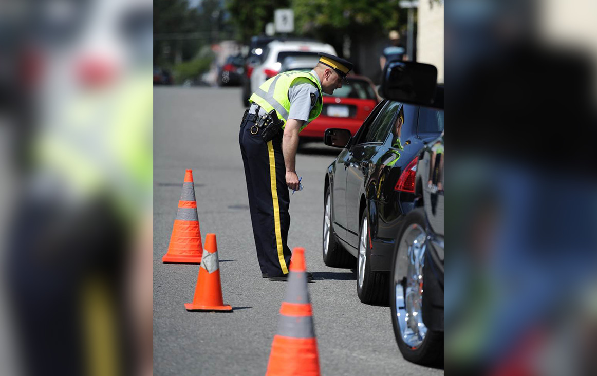 FILE. An RCMP officer performs a road check in Kelowna, B.C.