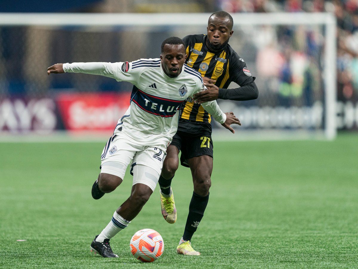 JC Ngando of the Vancouver Whitecaps, front, fends off Gerson Chavez of Real Espana during CONCACAF Champions League soccer action in Vancouver, B.C., Wednesday, March 8, 2023.
