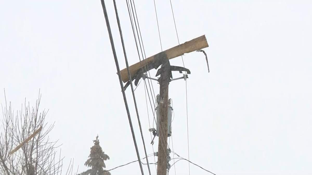 Debris is seen atop a telephone pole near a Calgary house fire on March 27, 2023.