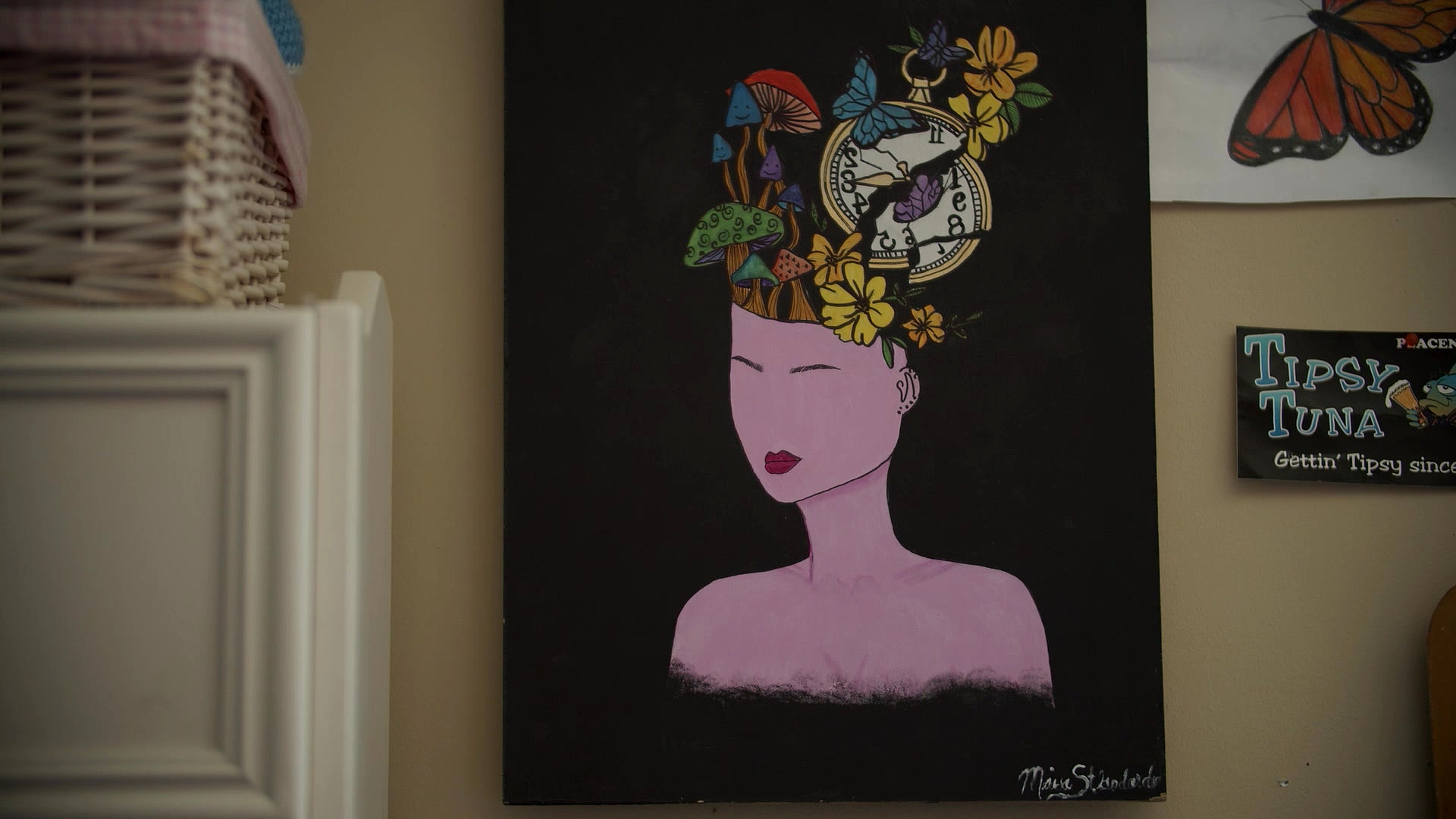 There’s a portrait of a woman on a black background, with her mind cracked open, and vibrant thoughts spilling out of it. Expansion of the Mind is what St. Godard calls the piece, a nod to her own transformation after a number of challenging years.