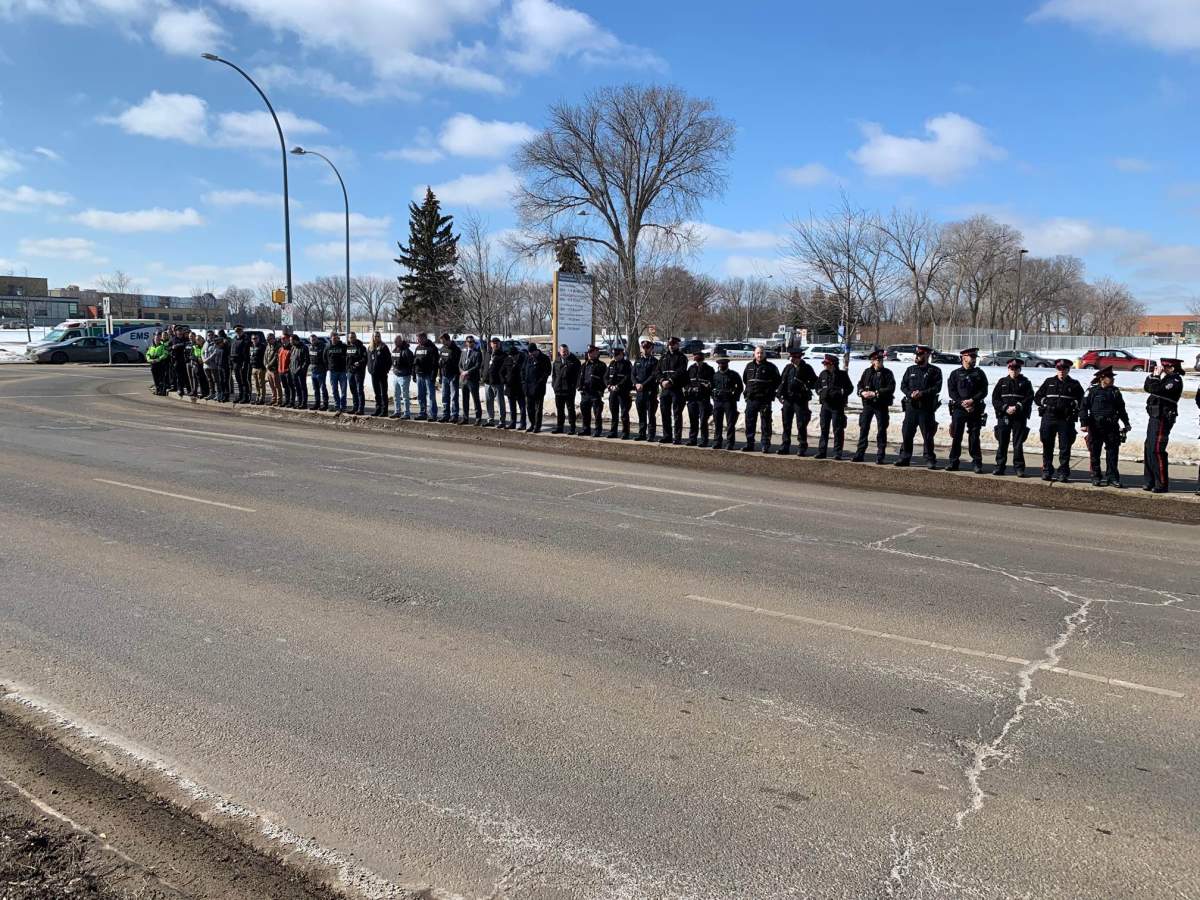 Blue ribbons are wrapped around street lights along the five-kilometre procession route taking two slain Edmonton police officers to the funeral home on Tuesday, March 21, 2023.
