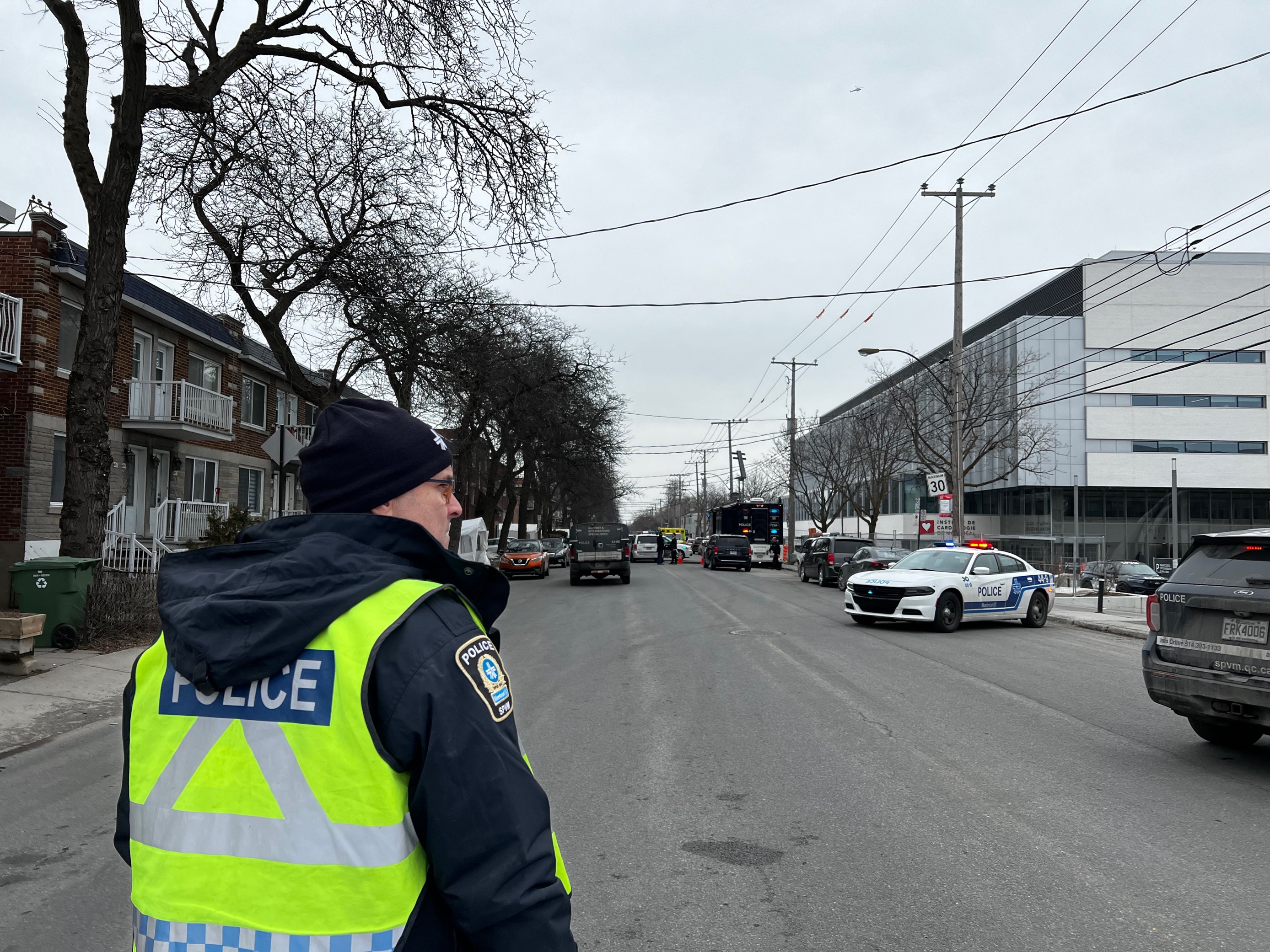 A Montreal police officer is pictured at the scene near the intersection of Viau and Belanger Streets in the city's Rosemont-La Petite-Patrie borough. Friday, March 17, 2023.