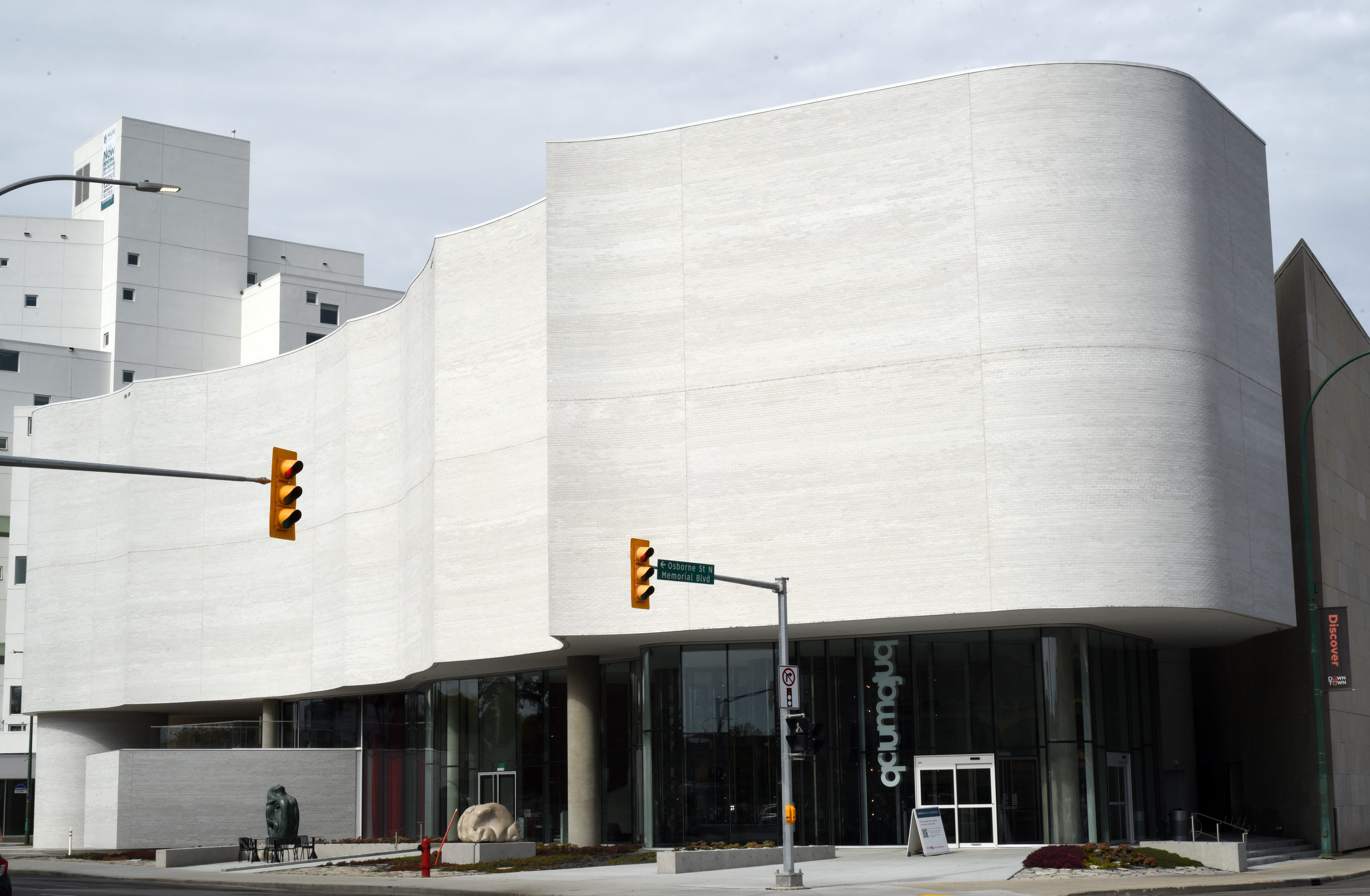 A curved, white building on the corner of a downtown Winnipeg street. It's the addition to the Winnipeg Art Gallery, Quamajuq, a new centre of Inuit art and culture.