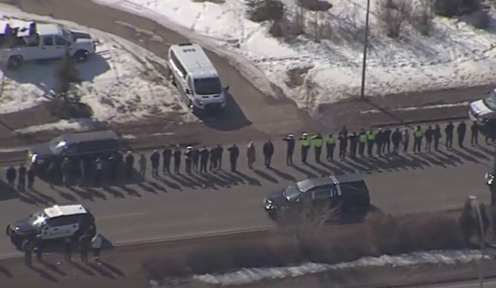 Hundreds of Edmonton police officers, Alberta first responders and other Edmontonians lined the streets of Alberta's capital on Tuesday to pay tribute to two slain constables as their bodies were taken to a funeral home.