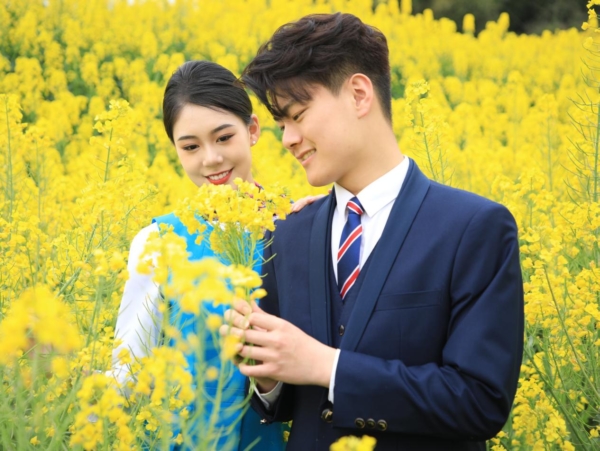 Photo of two people in a field of flowers, posted by a Chinese vocational college on March 23 to promote a newly extended spring break that encourages students to "fall in love."
