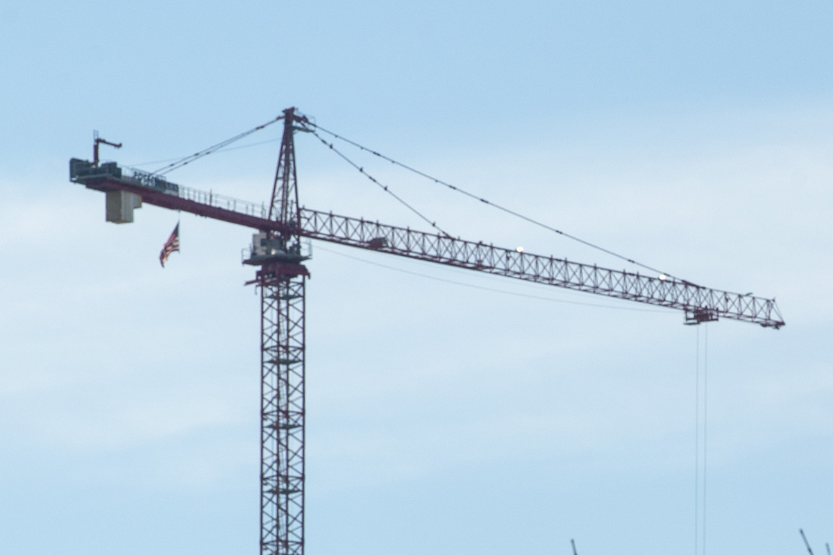 A construction crane hovers over a structure.
