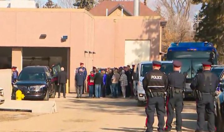 The caskets holding Const. Brett Ryan and Const.Travis Jordan's bodies, which were decorated in Canadian flags, were loaded into hearses outside the city's medical examiner's office at about noon on Tuesday as members of their family stood close by. Members of the Edmonton Police Service's Guard of Honour, a group of EPS members who also serve as ambassadors to the public, were also there while Chief Dale McFee was standing with other police officers on a sidewalk nearby.