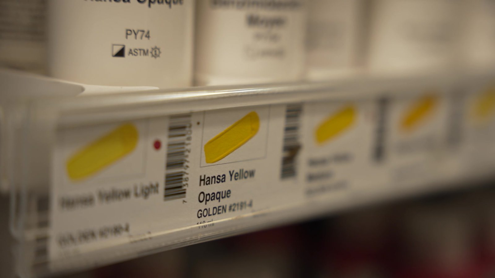 Similar shades of yellow paint on art store shelves.
