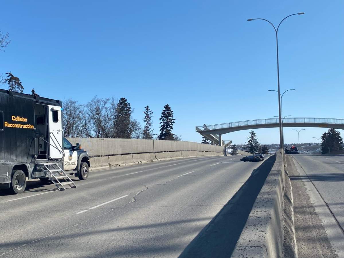A motorcycle lays on its side on Macleod Trail with police nearby following a fatal collision on March 31, 2023.