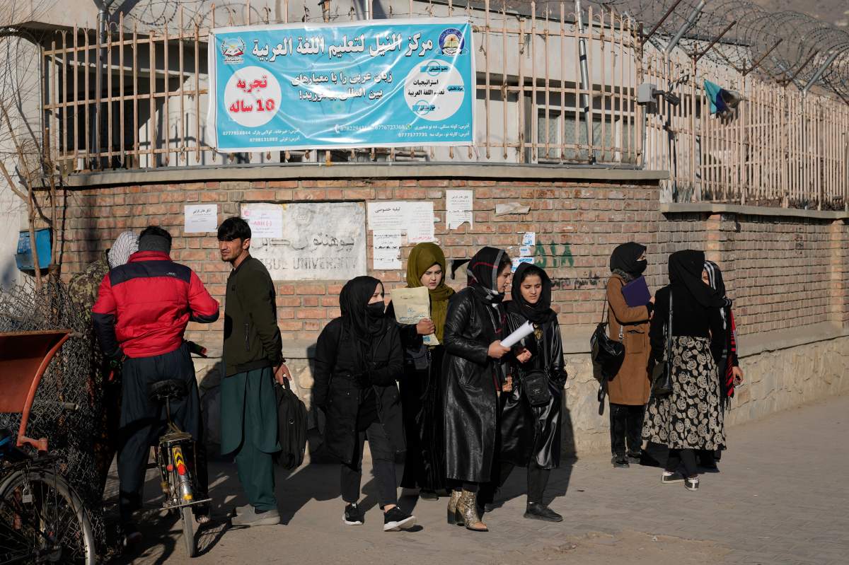 Women stand outside Kabul University after the Taliban ordered women barred from education