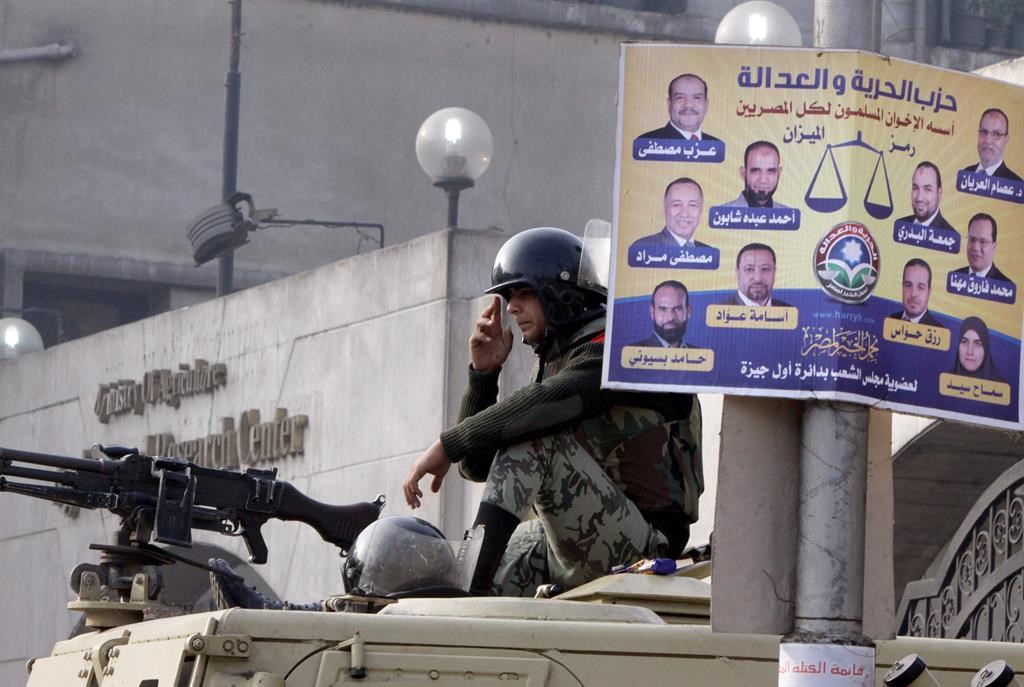 An Egyptian soldier sits on his armoured vehicle in front of a Freedom and Justice Party Arabic-language poster supporting Muslim Brothehood candidates outside a ballot counting centre in Giza, Egypt, Fri. Dec. 16, 2011. The party and the Brotherhood have since been outlawed. Egyptian asylum seekers spoke Monday alongside NDP MP Don Davies at his constituency office in Vancouver, decrying the CBSA's treatment of recent claimants affiliated with the Freedom and Justice Party and the potential denial of their refugee bids. 