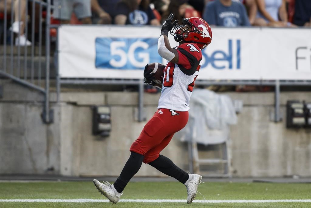 Calgary Stampeders running back Peyton Logan (20) celebrates after scoring a touchdown against the Toronto Argonauts during first half CFL football action in Toronto, Saturday, Aug. 20, 2022. Stampeders games will be broadcast on QR Calgary's AM and FM radio stations for the first time in the team's history. THE CANADIAN PRESS/Cole Burston.