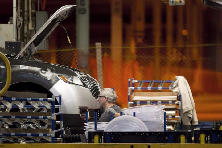 A line worker works on a car at Ford Motor plant in Oakville, Ont., on Friday, January 4, 2013. Ford Motor Co. says it will invest $1.8 billion in its Oakville Assembly Complex to turn it into an electric vehicle production hub. .