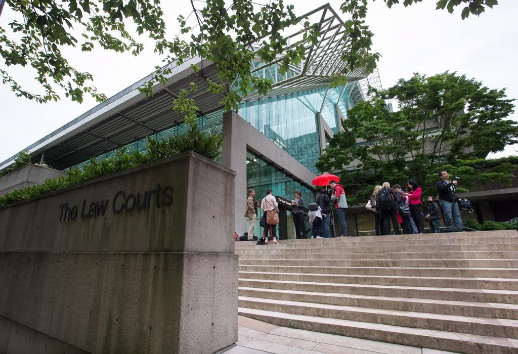 Media wait outside court in Vancouver, B.C., June 2, 2015.