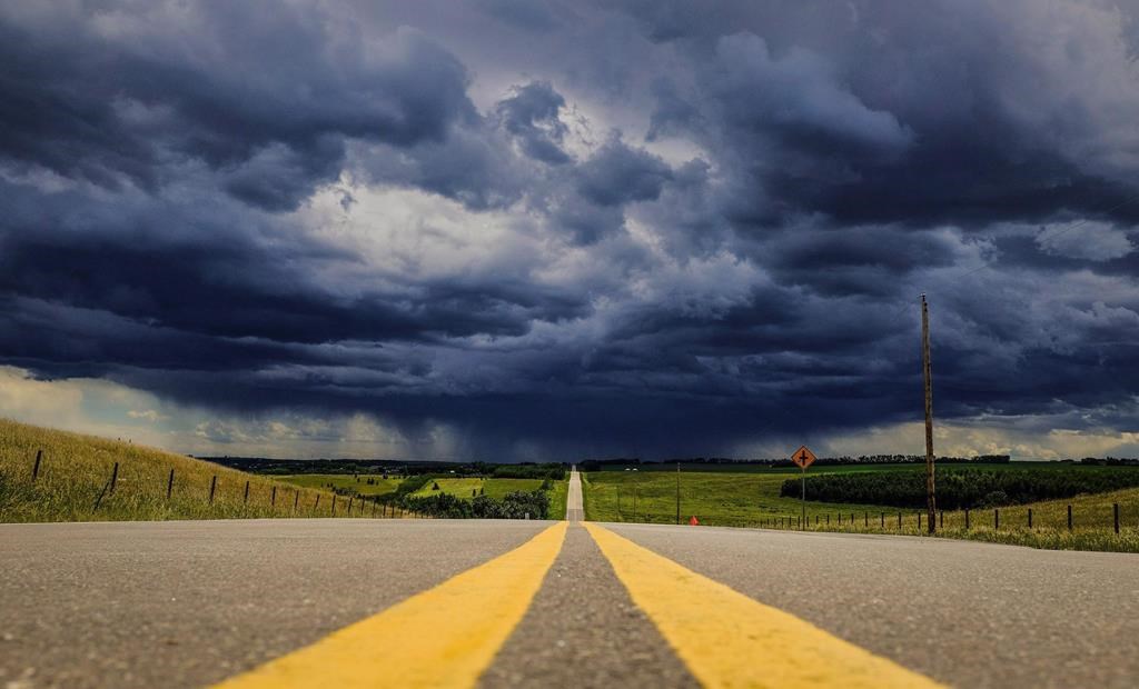 Storm clouds build over a highway in southern Alberta near the town of Carstairs on Monday, July 4, 2016. Tourmaline Oil Corp. says it will partner with California-based Clean Energy Fuels Corp. to build and operate a network of compressed natural gas (CNG) fuelling stations along highway corridors in Western Canada.