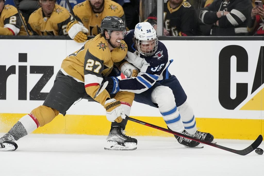Vegas Golden Knights defenceman Shea Theodore (27) and Winnipeg Jets centre Morgan Barron (36) vie for the puck during the third period of Game 1 of an NHL hockey Stanley Cup first-round playoff series Tuesday, April 18, 2023, in Las Vegas.
