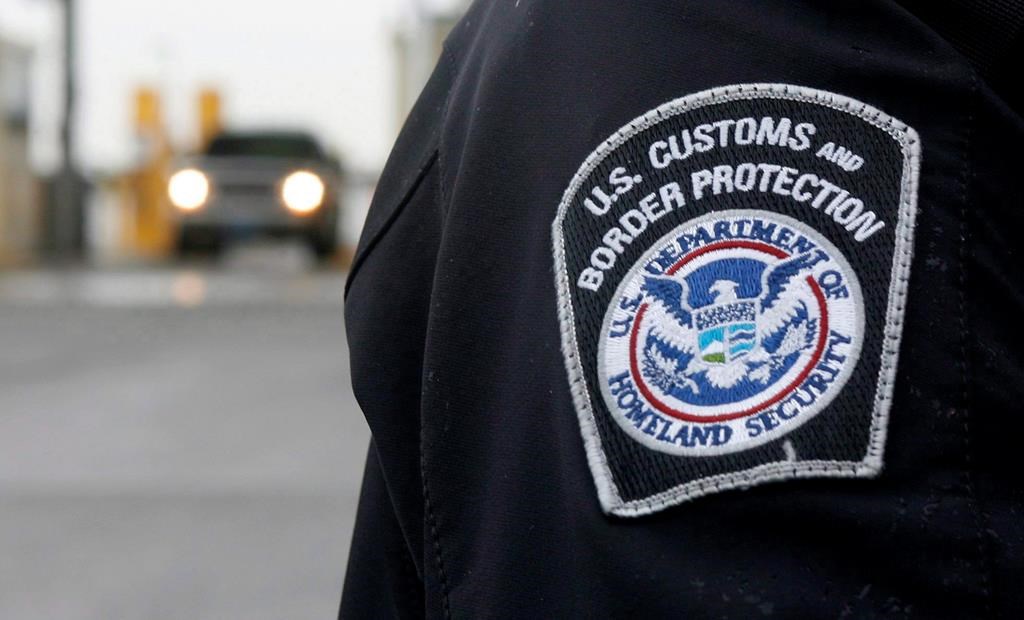 A U.S. Customs and Border Protection officer stands near a security booth as vehicles approach in Detroit, Mich, on Monday, June 1, 2009. U.S. officials say at least seven of the nine men caught crossing the border from Canada this week in southeast Manitoba are Mexican citizens. THE CANADIAN PRESS/Dave Chidley.