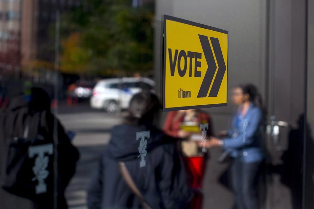 Voters line up outside a voting station to cast their ballot in the Toronto's municipal election in Toronto on Monday, Oct. 22, 2018.
