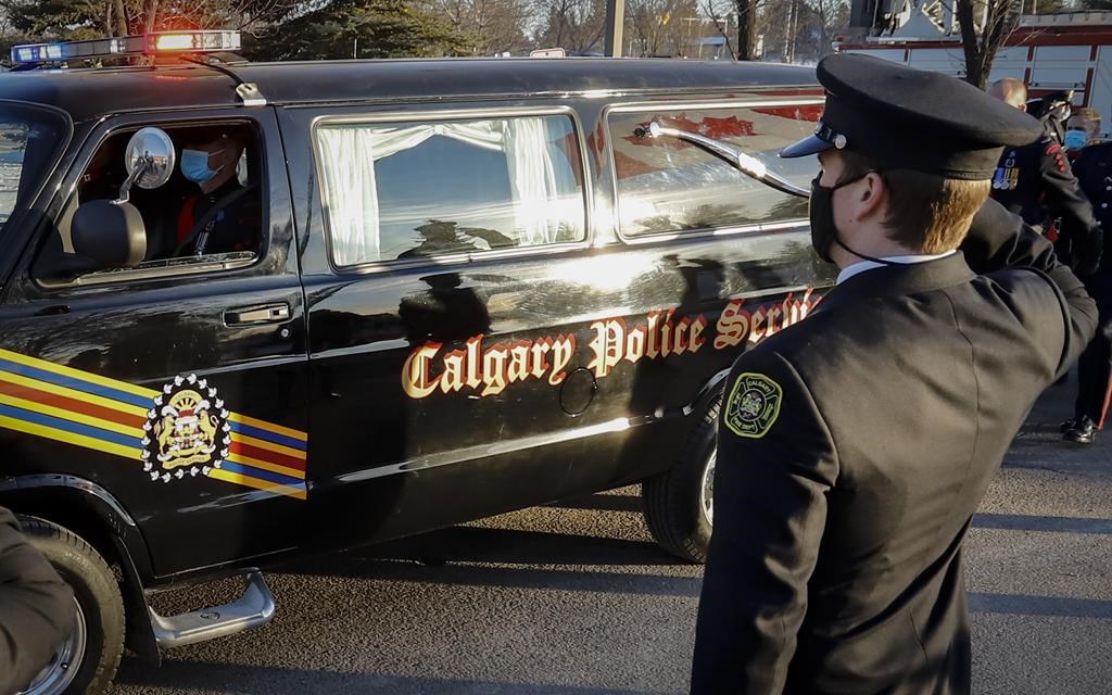 Fire fighters salute as the hearse and honour guard pass by at the regimental funeral service for Calgary Police Service Sgt. Andrew Harnett in Calgary, Alta., Saturday, Jan. 9, 2021.  