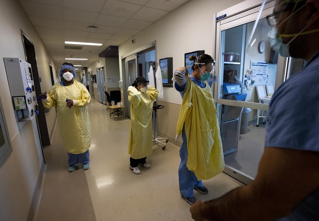 Nurses put on personal protective equipment at the Humber River Hospital in Toronto on Tuesday, January 25, 2022.  THE CANADIAN PRESS/Nathan Denette.