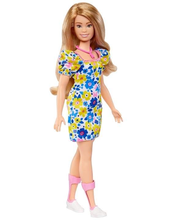 A Barbie doll with Down syndrome with light brown hair and wearing a colourful dress along with ankle braces