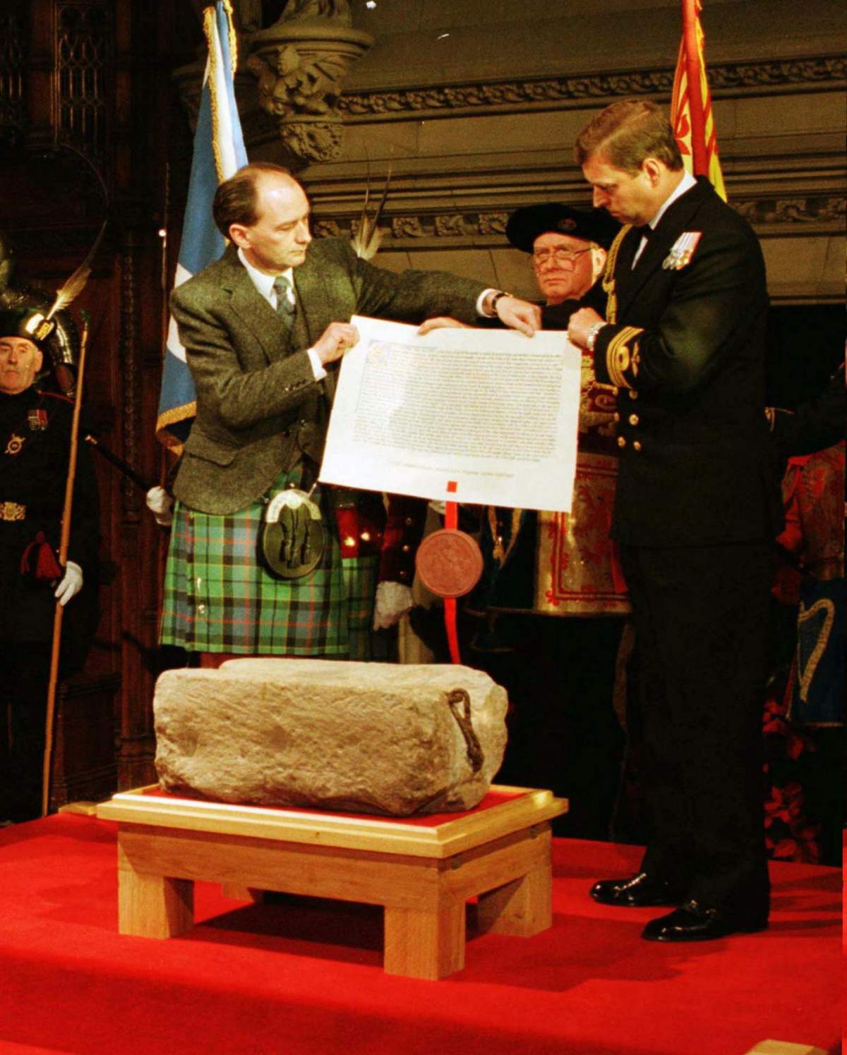 ** FILE ** Britain’s Prince Andrew, right, prepares to hand over the Royal Warrant to Scottish secretary Michael Forsyth, left, for the safe keeping of the Stone of Scone, during a ceremony in in the Great Hall of Edinburgh Castle, in this Saturday Nov. 30, 1996 file photo. The stone slab, weighing 458 pounds (208 kgs), was the coronation seat of Scottish kings until it was carried away to England as war booty by King Edward I in 1296, and placed in the coronation chair in London’s Westminster Abbey, where it has been involved in all coronations since. (AP Photo/Chris Bacon)