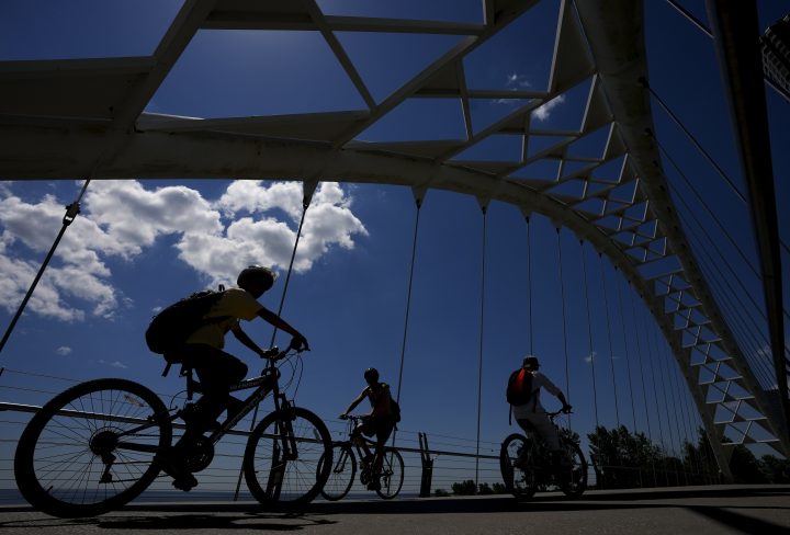 Cyclists enjoy the outdoors on a hot day as they ride across the Humber Bay Bridge in Toronto on Thursday, June 23, 2022. 