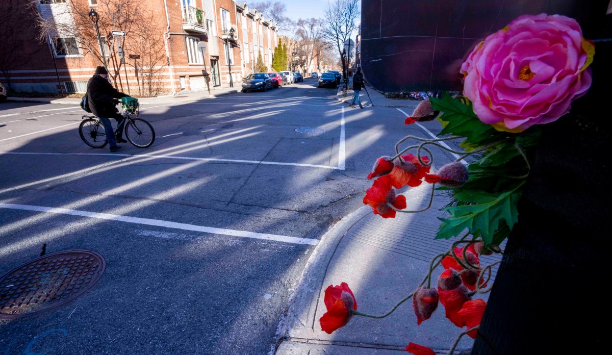 A cyclist crosses the street on the corner where a seven-year-old girl was killed in a hit and run Tuesday, in Montreal, on Wednesday, Dec. 14, 2022.
